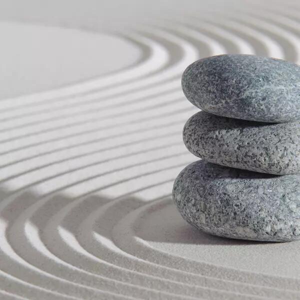 Image of stacked stones on sand to represent news item on "AMAPCEO gets action: Customary limits removed for OPS members’ paramedical benefits"