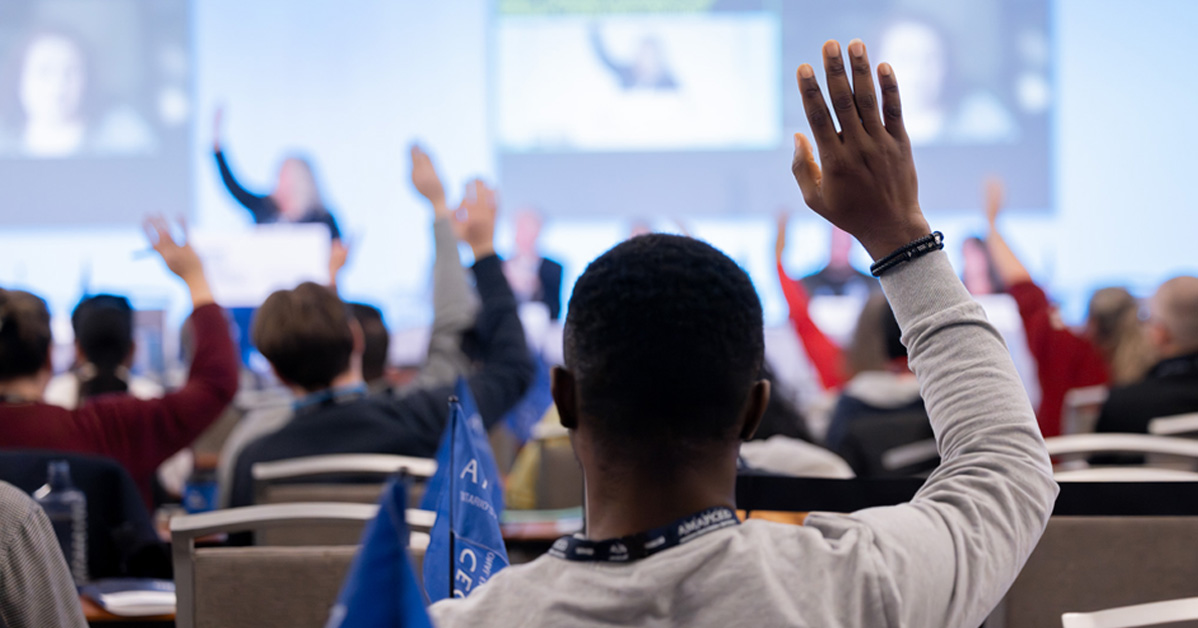 Image of Delegates holding hands up.