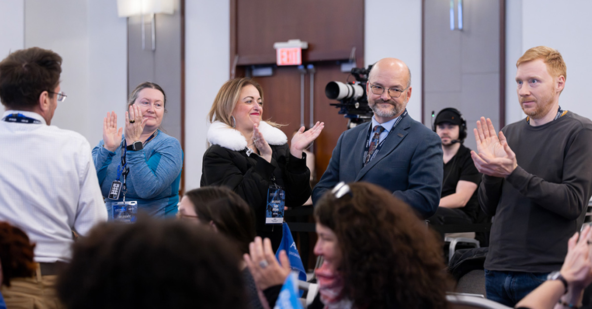 Image of Delegates congratulating Tim Sim on being re-elected as Secretary to AMAPCEO's Executive Committee.