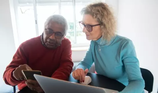 Two people looking at a laptop