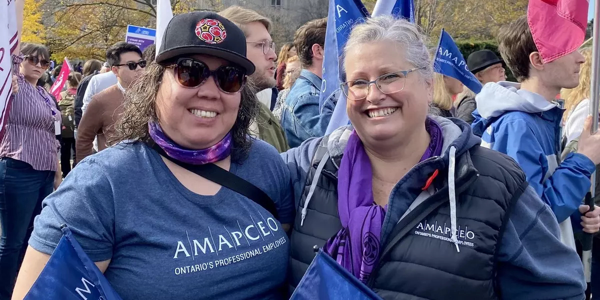 Cynthia Watt and Waasmowin-Mnidoo waving AMAPCEO flags