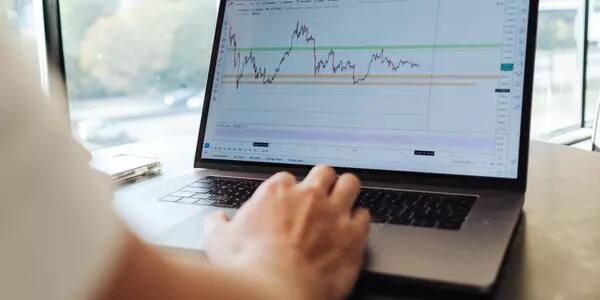 A person using a laptop computer that is displaying financial analytics