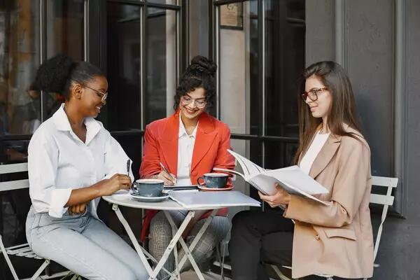 A group of women looking at papers and drinking coffee