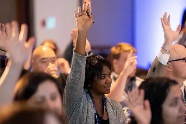 A group of AMAPCEO Delegates raising their hand to vote 