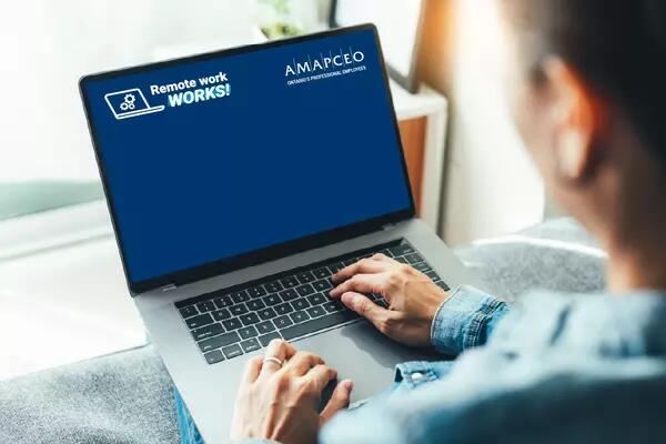 A person at a laptop with the AMAPCEO Remote Work WORKS! Virtual Background on the screen.