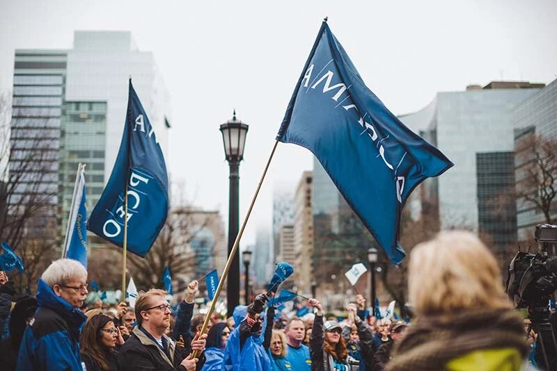 A group of members with AMAPCEO flag at a solidarity rally in front of Queen's Park