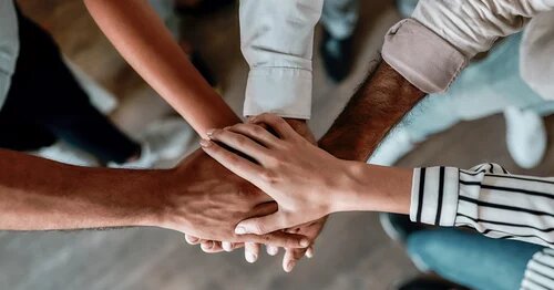 Image of hands in a group together celebrating team work