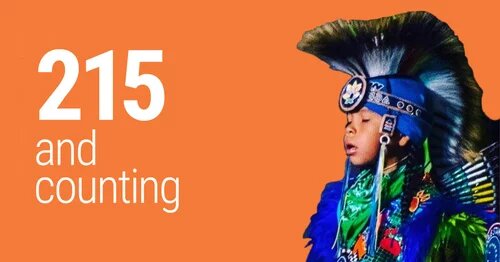 215 and counting - with a young Indigenous person in traditional clothing
