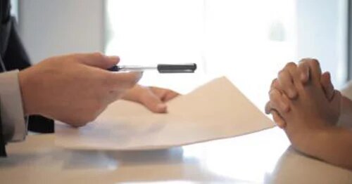 Image of two sets of hands where one set is showing a piece of paper to the other set