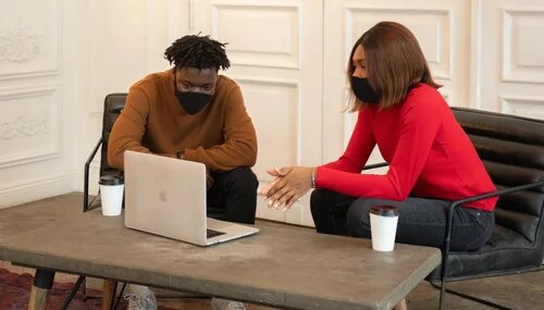 Two AMAPCEO members wearing masks looking at a laptop