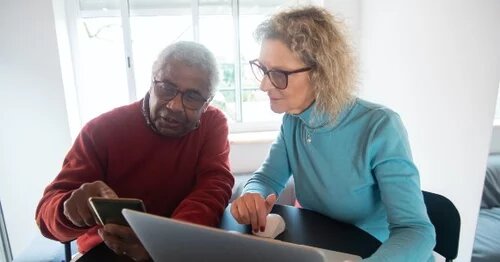 Two people looking at a laptop
