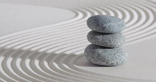 Image of stacked stones on sand to represent news item on "AMAPCEO gets action: Customary limits removed for OPS members’ paramedical benefits"