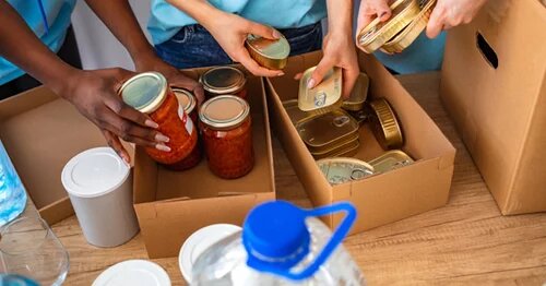 Image of volunteer's hands packing donation boxes