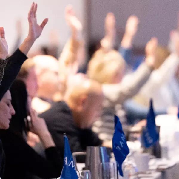 Members raising their hands to vote