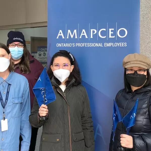 Photo of several masked AMAPCEO members holding AMAPCEO swag