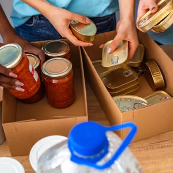 Image of volunteer's hands packing donation boxes