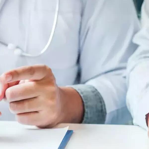 Image of two sets of hands, one holding a pill container