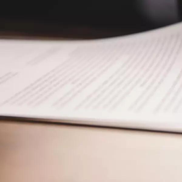 Image of hand with pen on document